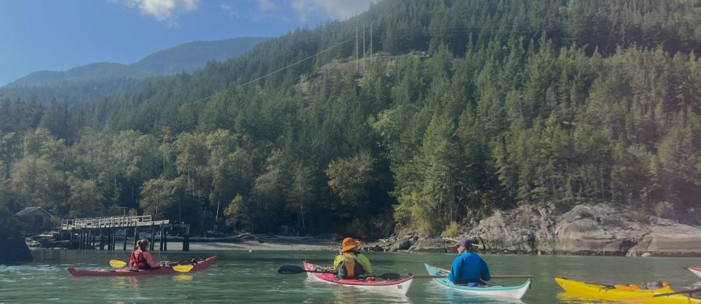sea kayakers arriving at Zorro Bay/Ts’itpsm, Howe Sound, British Columbia