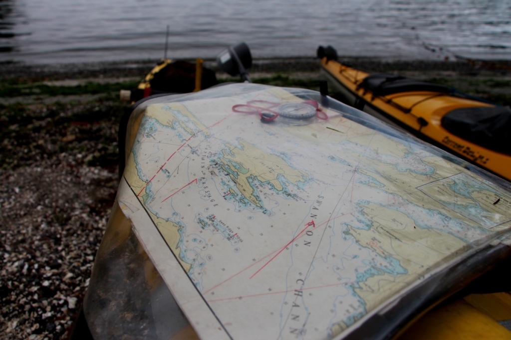 Showing a chart in a chart bag on the deck of a sea kayak, for comparison to the "map" page of a portable GPS.
